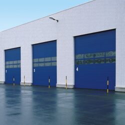 Hormann blue sectional overhead doors in a grey industrial unit, with numbered bays visible on the door fronts.