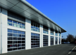 Industrial sectional doors with double-skinned glazed panels and steel framing on a modern warehouse exterior from Westcoast Doors Ltd.