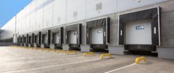 Loading bay doors and dock levellers with grey steel and yellow safety rails, showing multiple bays and support plates for safe loading and unloading.